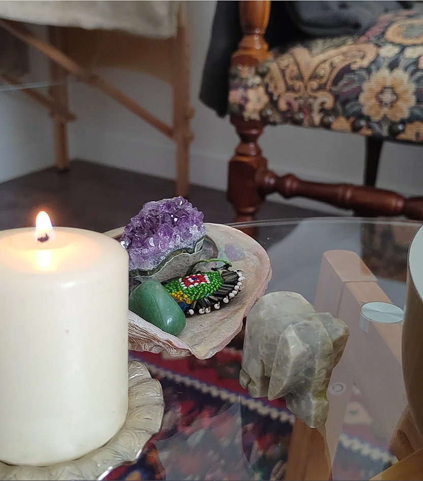 Bougie rituelle, améthyste brute et pierre d'aventurine verte sur une table