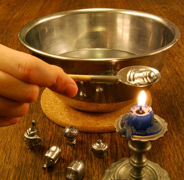 Cuillère remplie de plomb tenue au dessus d'une bougie